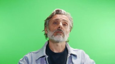 Olgun adam yeşil ekranda konuşma yapıyor.