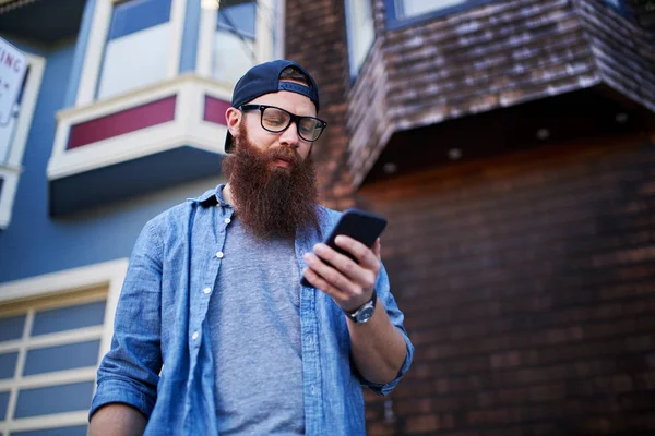 Бородатий хіпстер за допомогою смартфона — стокове фото