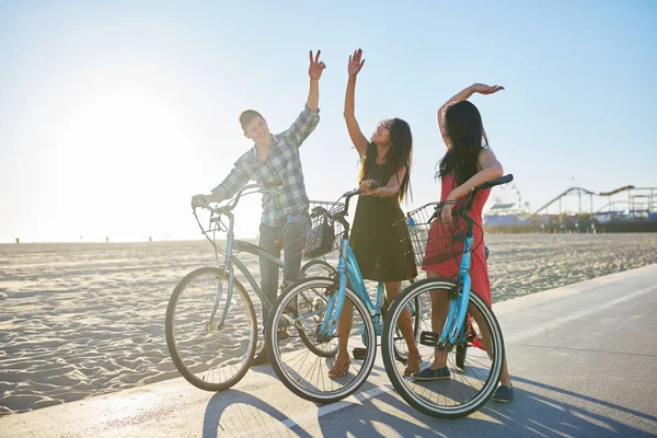 Amigos em bicicletas fazendo alta cinco — Fotografia de Stock