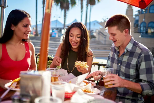 Tres amigos disfrutando de la comida — Foto de Stock