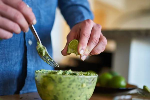 Hombre añadiendo jugo de lima al guacamole — Foto de Stock