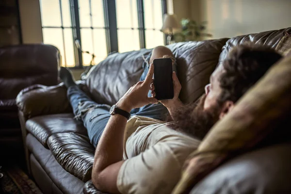 Skäggig kille som använder smart telefon — Stockfoto