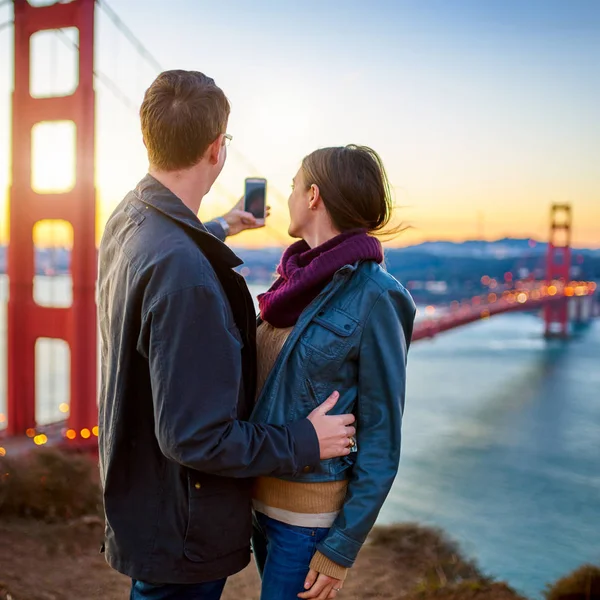 Couple in front of golden gate bridge — Stock Photo, Image