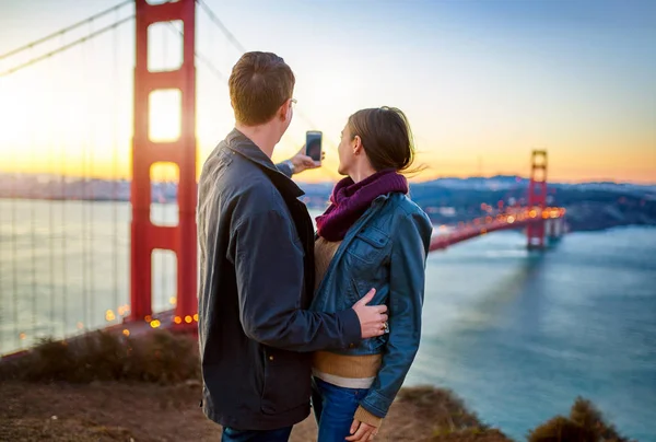 Casal na frente da ponte portão dourado — Fotografia de Stock