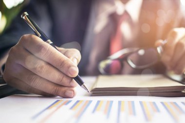 Ofiste çalışan işadamı bilgisayarında, tabletinde ve çalışma masasında veri dokümanlarıyla çalışıyor..
