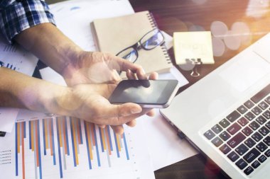 Modern cihazlar, dijital tablet bilgisayar ve cep telefonuyla çalışan genç işadamı.