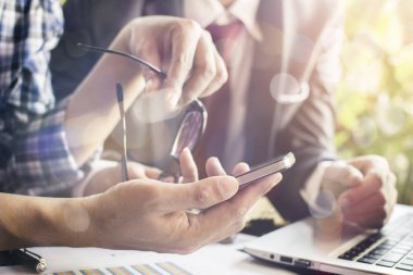 Takım çalışması. Genç işletme yöneticileri yeni bir proje üzerinde çalışıyor. Tahta masadaki labirent 