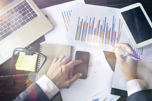 Modern cihazlar, dijital tablet bilgisayar ve cep telefonuyla çalışan genç işadamı.