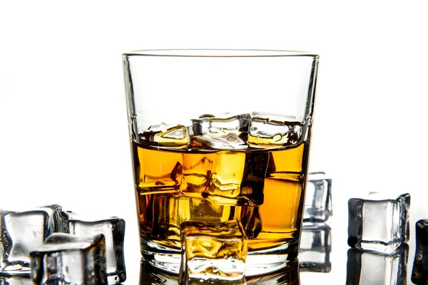 Glass of whiskey and ice cubes.Isolated shot of whiskey.Glass of scotch and ice cubes on a white background.