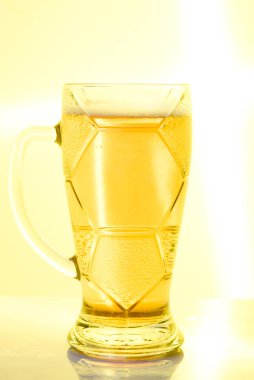 Sarı arka planda bira kupası.