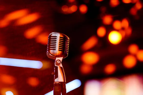 Karaoke background.Silver vintage microphone on bokeh.Close-up of retro microphone at concert.Professional microphone