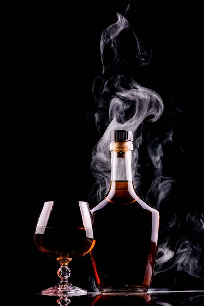 Bottiglia Bicchiere Whisky Cognac Con Fumo Fondo Scuro — Foto Stock