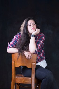 Rahat bir kıyafet içinde karanlık bir uzun saçlı güzel artı boyutu modeli