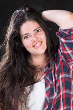 Rahat bir kıyafet içinde karanlık bir uzun saçlı güzel artı boyutu modeli
