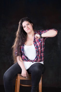 Rahat bir kıyafet içinde karanlık bir uzun saçlı güzel artı boyutu modeli