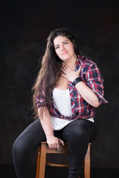 Beautiful plus size model with a dark long hair in a casual outfit — Stock Photo, Image