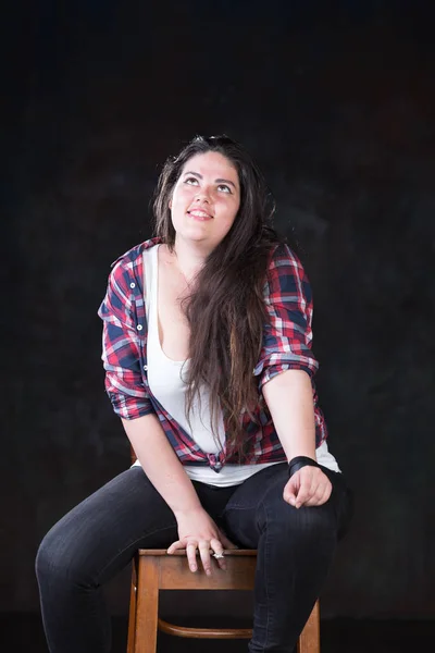 Beautiful plus size model with a dark long hair in a casual outfit — Stock Photo, Image