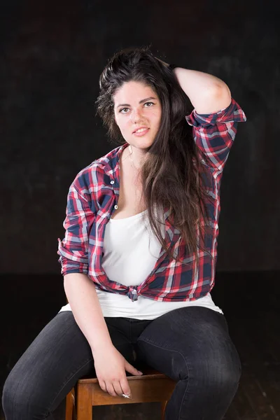 Beautiful plus size model with a dark long hair in a casual outfit — Stock Photo, Image