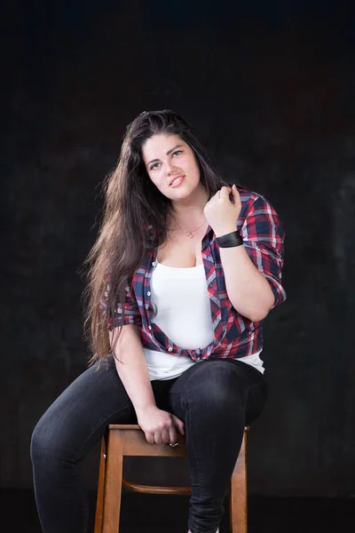 Mooie plus size model met een donkere, lange haren in een casual outfit — Stockfoto