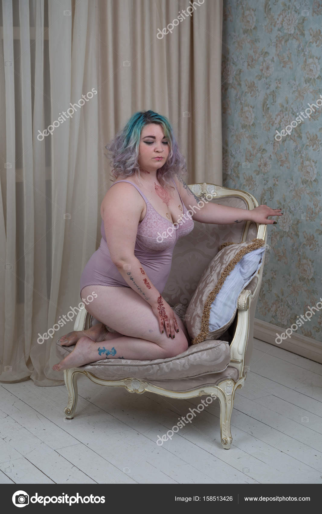 Plus size female model with alternative look, tattooed, with coloured hair,  in lingerie. Stock Photo by ©byazrov 158513426