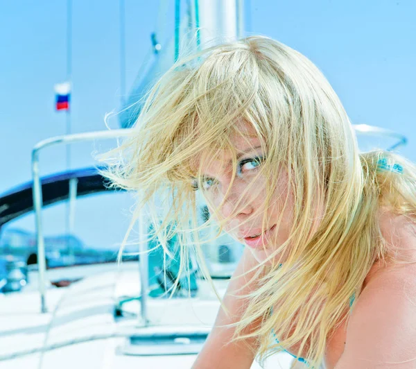 Beautiful young blond female model sunbathing on a yacht in the sea — Stock Photo, Image