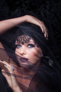 Genç sarışın kadın modeli'nın yakın çekim güzellik portre ile göz alıcı makyaj. O siyah dantel karakul önlüğünü döşeme kaplıdır.