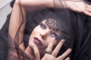 Genç sarışın kadın modeli'nın yakın çekim güzellik portre ile göz alıcı makyaj. O siyah dantel karakul önlüğünü döşeme kaplıdır.