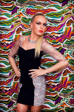 Renkli arka plan üzerinde fantezi tasarımcı elbiseli sarışın kadın modeli