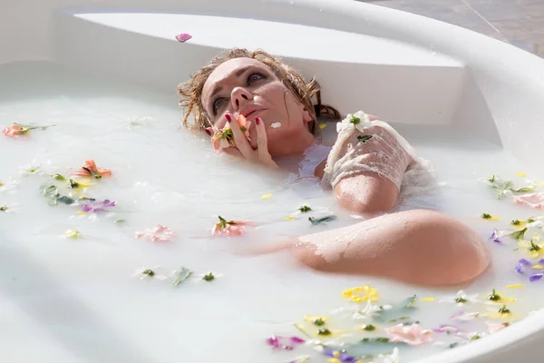 Hermosa mujer rubia relajándose en una bañera de hidromasaje . — Foto de Stock