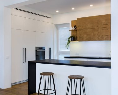 Hafif iç ahşap desenli modern mutfak tasarımı. Odaya bir mutfak yarımada mevcuttur. Kombine mutfak ve oturma odası. Mutfak ahşap cepheler ceviz kaplama yapılır.