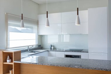 Ahşap aksan ile hafif iç modern mutfak mobilyaları tasarımı. Mutfakta ki yarımada odada. Taş yüzey. Parlak cepheler. Proje bitti. Beyaz kolye ışığı. Lavabo, pencere, panjur. Cam.