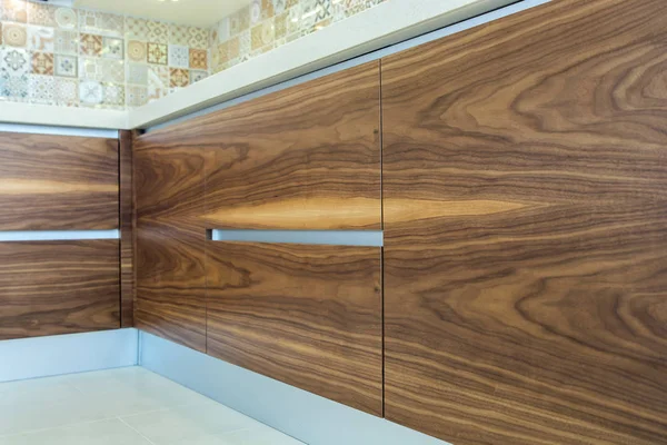 Modern home interior. Wood texture. Wooden surface of the kitchen facades are made from walnut veneer. European furniture, design, technologies. Fine design — Stock Image Modern Home Interior Wood Texture Wooden Surface Kitchen Facades Made Stock Picture