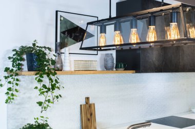 Modern ev iç. Hafif iç modern mutfak tasarımı. Cepheler boyalı ve doğal taştan yapılmış. Avrupa mobilya, tasarım, teknoloji. Kolye ışık.