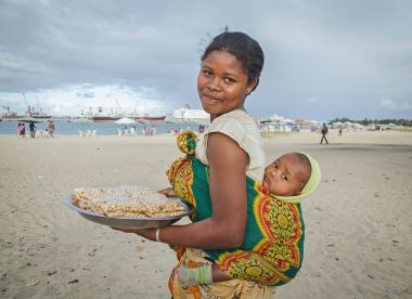 Madagaskar bir kız bebeği ile 11 Temmuz 2016 fıstık sahilde, Toamasina, Madagaskar satmaktadır