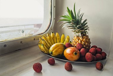 Pencerenin yakınındaki tropikal meyve ile bir tepsi