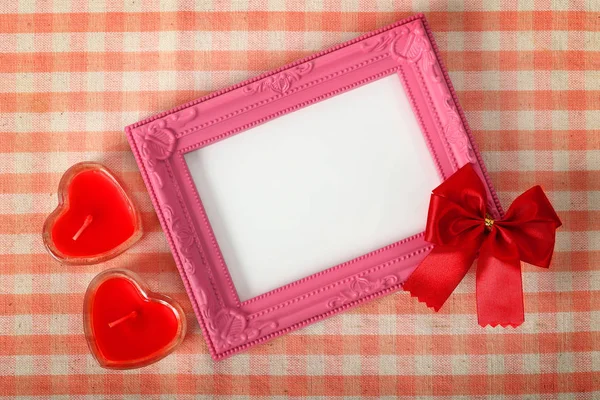 Empty pink photo frame and red ribbon next heart sign over the f — Stock Photo, Image