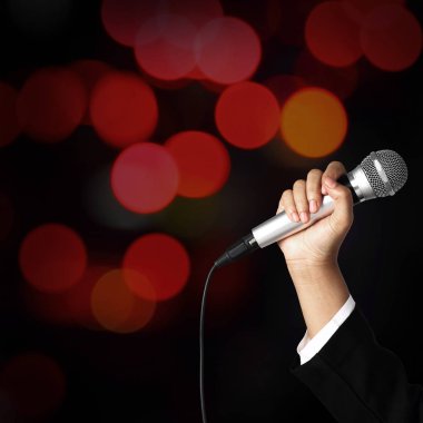 kadın el holding mikrofon bulanıklık bokeh arka plan üzerinde