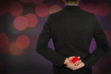 Alyans ve kırmızı hediye kutusu bokeh üzerinde olan adam