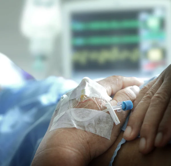 Tangan pasien dengan solusi iv ditata dan monitor mengaburkan latar belakang — Stok Foto