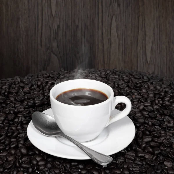 Черный кофе и кофейные зерна с дымом — стоковое фото