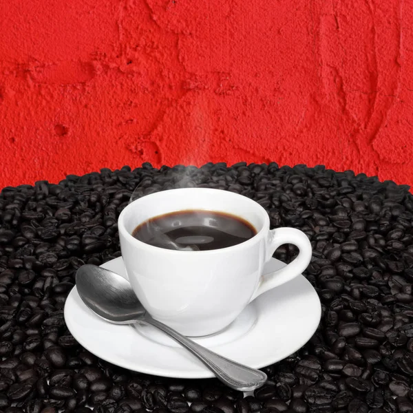 Café noir et grains de café avec fumée sur le mur de ciment rouge . — Photo