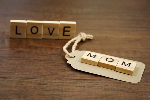 Love mom wording with paper label on wood — Stock Photo, Image