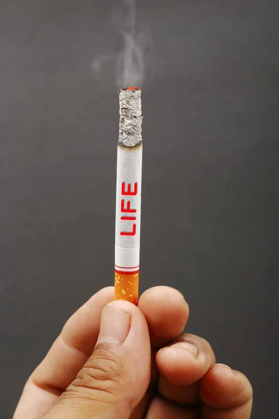 Dohányosok cigaretta, sötét kézzel — Stock Fotó
