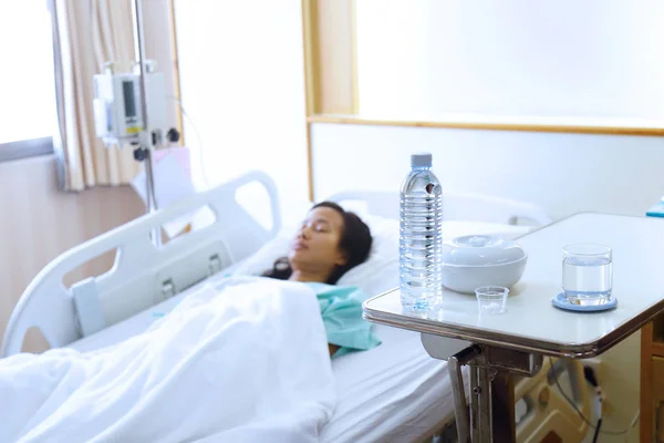 Пациент застужен спящим в постели с лекарствами и водой в — стоковое фото