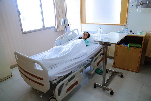 Patienten fångat kallt sover i sängen med läkemedel och vatten i Stockbild