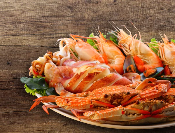 Karışık deniz ürünleri ızgara ve salata yaprakları üzerinde ahşap 