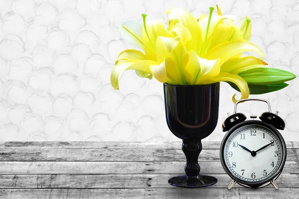 黄色いリリー花とビンテージ背景の時計 — ストック写真