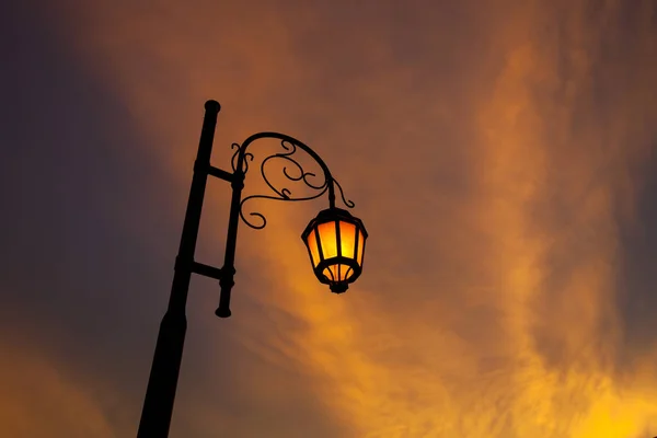 Vintage illuminated street lamps orange light with sunset cloud — Stock Photo, Image