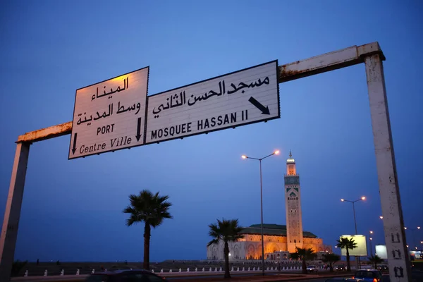 Señal de tráfico a la mezquita Hassan II durante el crepúsculo en Casablan Imagen de stock