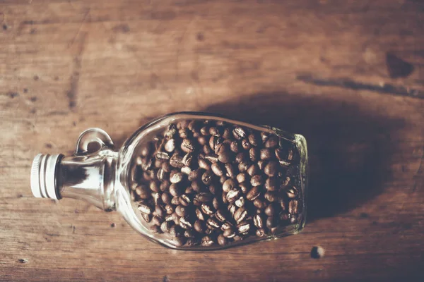 Top Vier de granos de café (Peaberry) dentro de la botella transparente, Fo Fotos de stock